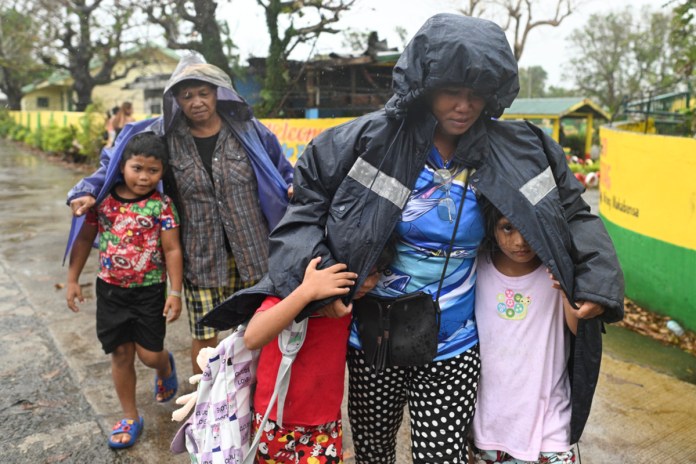 Vecinos utilizan chaquetas para protegerse de la lluvia mientras evacúan sus casas en Santa Ana, provincia de Cagayán, en el norte de Filipinas, mientras el tifón Usagi se aproxima el jueves 14 de noviembre de 2024. Foro: La Hora/AP