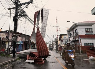 Un motorista pasa junto a un trozo de tejado colgado de cables eléctricos debido al tifón Man-yi, en una calle en el municipio de Baler, provincia de Aurora, en el nordeste de Filipinas, el lunes 18 de noviembre de 2024. Foto: La Hora/AP