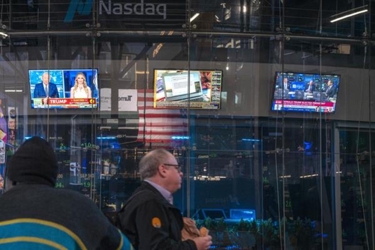 Un hombre camina frente a unos monitores de televisión, encendidos con reportes sobre las elecciones presidenciales, este miércoles en el edificio de Nasdaq en Nueva York (EE.UU.). Wall Street abrió este miércoles con sus tres principales índices -el Dow Jones de Industriales, el S&P 500 y el Nasdaq- repuntando con fuerza hacia máximos históricos, después de que esta madrugada se confirmara la victoria del republicano Donald Trump en las elecciones presidenciales de Estados Unidos. EFE/Ángel Colmenares