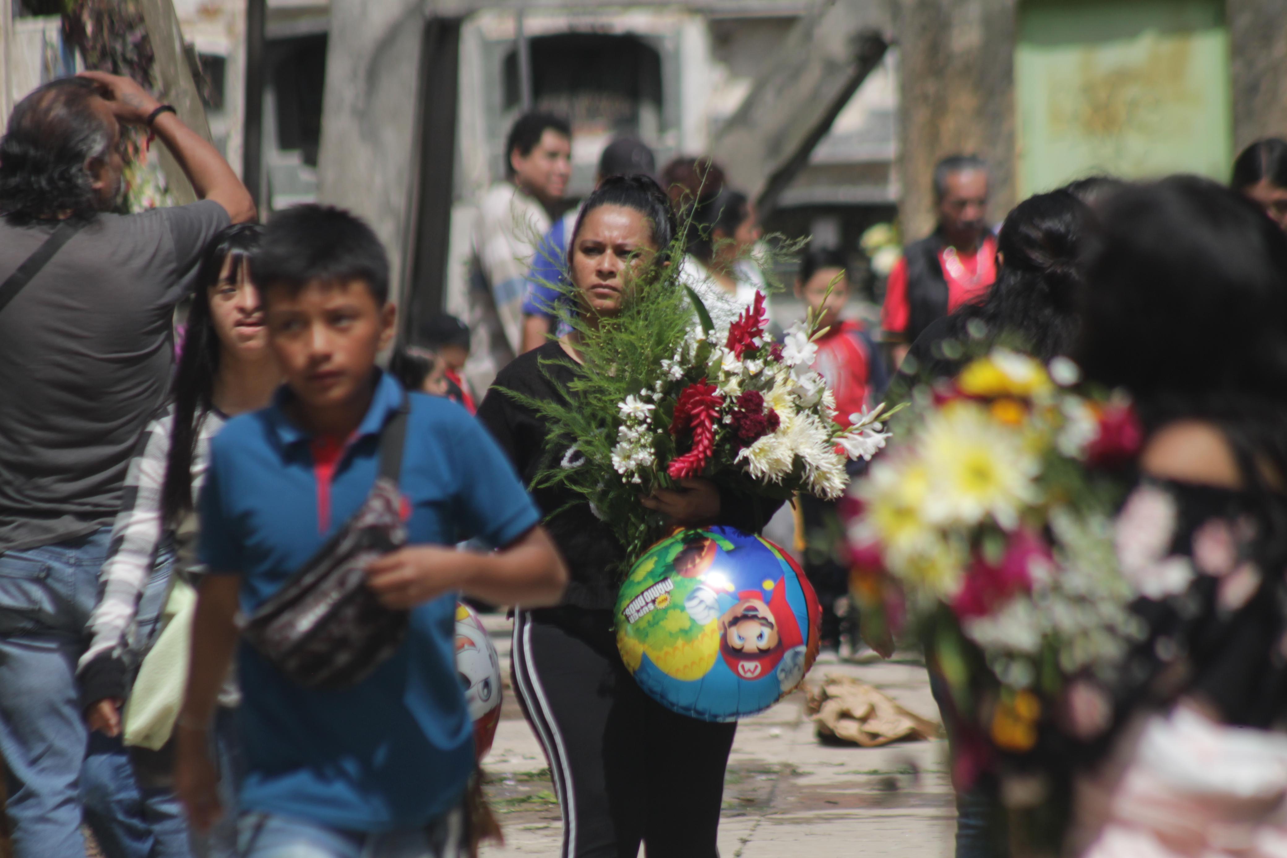 La colocación de flores en los panteones, es parte de las tradiciones del Día de los Santos. Foto La Hora: José Orozco. 