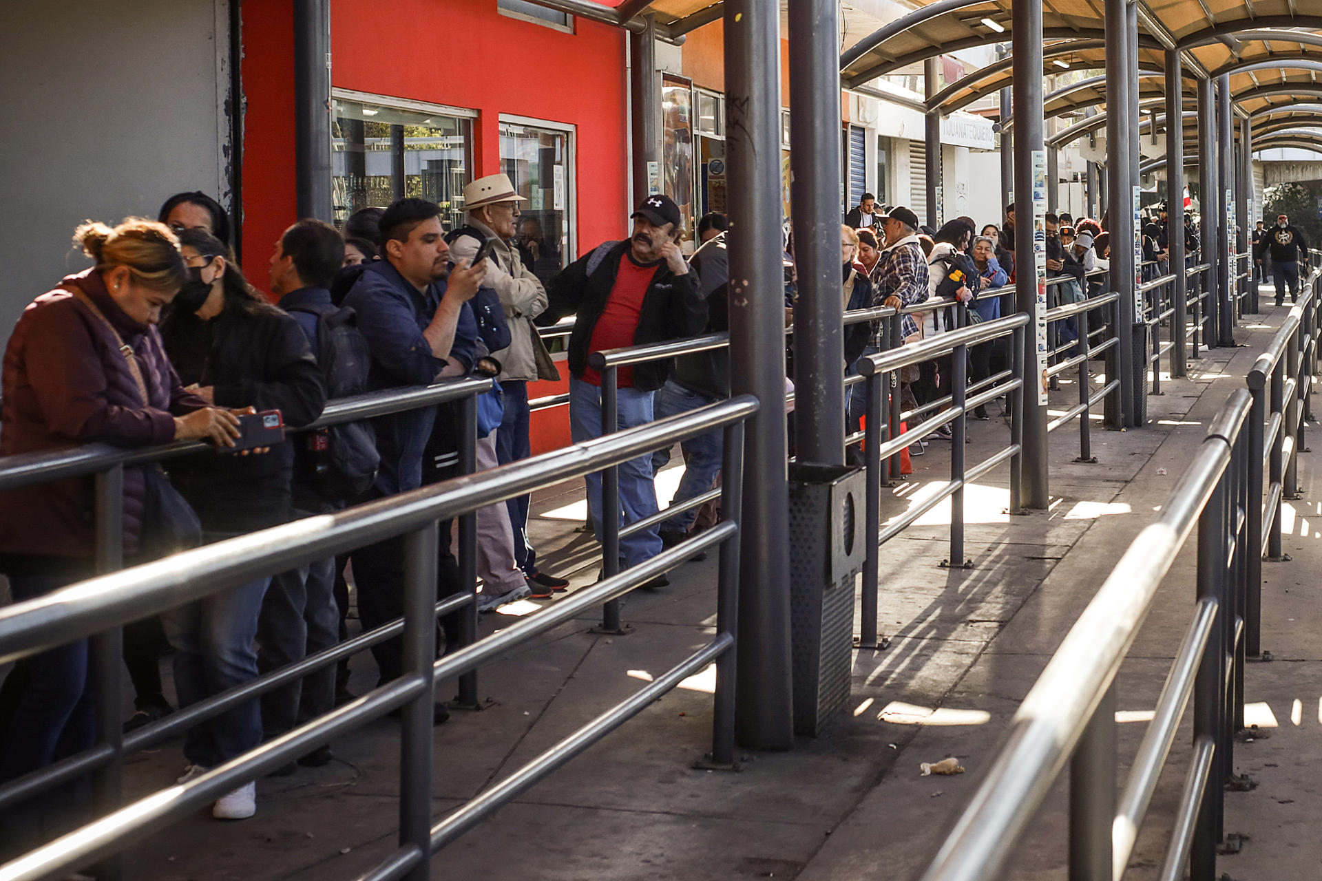 Varias personas hacen fila para cruzar la frontera hacia Estados Unidos por la garita de San Isidro, este martes en Tijuana (México). EFE/Joebeth Terríquez