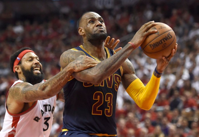 ARCHIVO - El delantero de los Toronto Raptors, James Johnson, comete una falta contra el delantero de los Cleveland Cavaliers, LeBron James, al final del cuarto cuarto del sexto partido de las finales de la Conferencia Este de la NBA, el 27 de mayo de 2016, en Toronto. Foto La Hora: AP