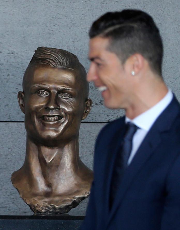 ARCHIVO - Cristiano Ronaldo pasa frente a un busto de sí mismo en el aeropuerto internacional de Madeira, Portugal, el 29 de marzo de 2017 Foto La Hora / AP - Armando Franca, archivo