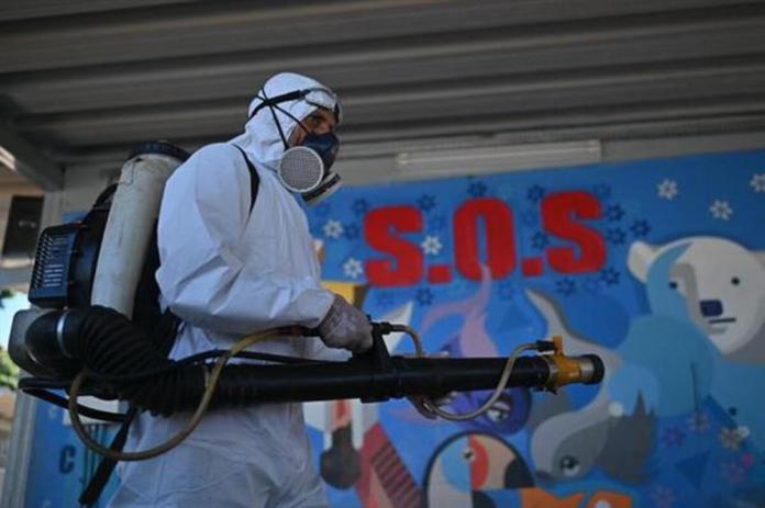 Un trabajador del sector de la salud fumigando contra el mosquito transmisor del dengue Aedes aegypti en una escuela de la región administrativa de Ceilandia en Brasilia Foto La Hora: EFE