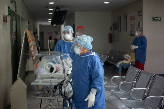 Trabajadores del sector salud trasladan a un bebé en el Instituto de Salud del Estado de México, en Toluca, en mayo de 2020. Monica Gonzalez (EL PAIS)