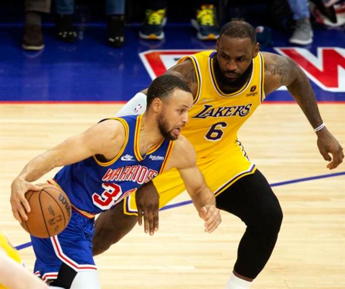 Fotografía de archivo en la que se registró al base estrella de los Warriors de Golden State, Stephen Curry (i), al intentar superar la marca del alero estrella de los Laker de Los Ángeles, LeBron James (d), durante un partido de la NBA, en el coliseo Chase Center de San Francisco Foto La Hora: EFE