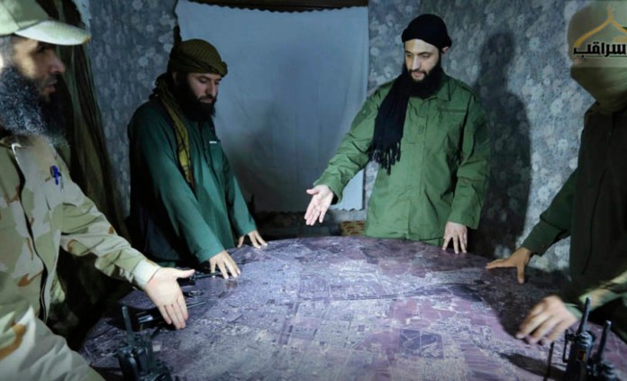 En esta imagen de archivo sin fecha, distribuida por un grupo insurgente en 2016, se muestra a Abu Mohammed al-Golani, el líder de la filial de Al Qaeda en Siria (segundo por la derecha), discutiendo detalles del campo de batalla con comandantes en Alepo, Siria. Foto La Hora: AP