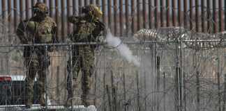 Un integrante de la Guardia Nacional de Texas dispara bolas de pimienta para dispersar a un grupo de migrantes este miércoles, en ciudad Juárez, Chihuahua (México).