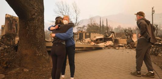 Altadena (United States), 09/01/2025.- Melissa Young (C) gets a hug from a neighbor while looking through the remains of her home that was destroyed by the Eaton wildfire with her brother Mark Mosher (R) in the Altadena, California, USA, 09 January 2025. According to the California Governor's office, more than 7,500 firefighting and emergency personnel are involved in response efforts, as multiple wildfires are continuing to burn across Southern California, destroying many homes and businesses, and forcing nearly two hundred thousand residents to evacuate in the Los Angeles area. (incendio forestal) EFE/EPA/ALLISON DINNER