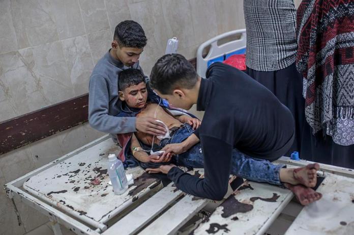 Dos niños ayudan a su hermano pequeño herido en el hospital Al Aqsa tras un ataque aéreo israelí en el campo de refugiados de Al Bureije, en la ciudad de Deir Al Balah, en el centro de la Franja de Gaza, el 4 de enero de 2025. EFE/EPA/MOHAMMED SABER