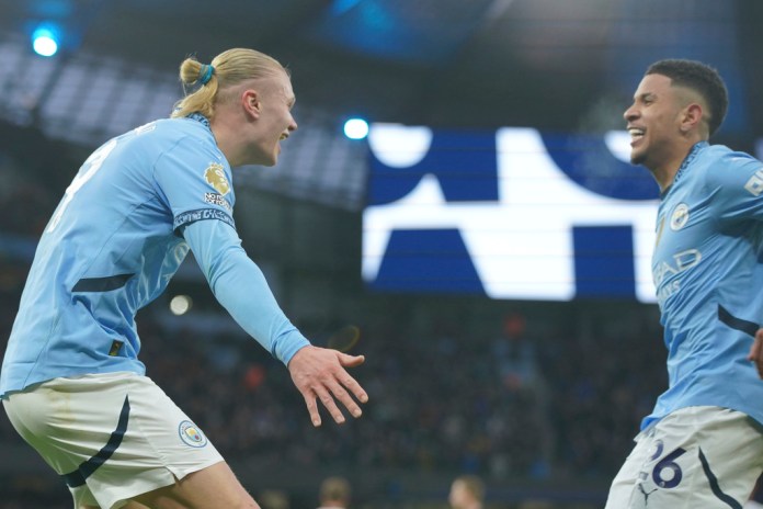 El noruego Erling Haaland, del Manchester City, festeja con el brasileño Savinho tras anotar ante el West Ham