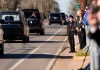 Un niño saluda al coche fúnebre que transporta el ataúd del expresidente Jimmy Carter.