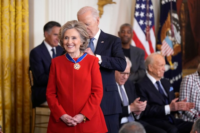 El presidente estadounidense Joe Biden le pone la Medalla Presidencial de la Libertad a la ex secretaria de Estado Hillary Clinton