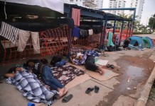 Migrantes durmiendo en un lado de una calle de Acapulco.