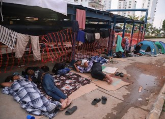 Migrantes durmiendo en un lado de una calle de Acapulco.