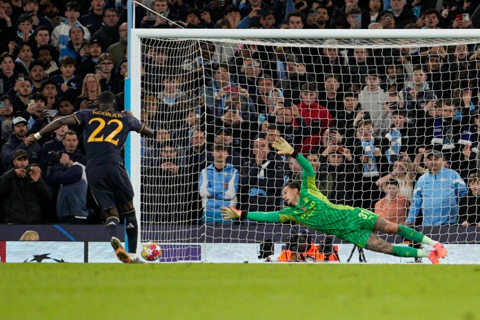 El portero del Manchester City, Ederson, a la derecha, no logra detener el balón cuando Antonio Rudiger del Real Madrid marca el penal ganador durante la tanda de penales durante el partido de vuelta de los cuartos de final de la Liga de Campeones entre el Manchester City y el Real Madrid en el Etihad Stadium en Manchester, Inglaterra, el miércoles 17 de abril de 2024. Foto La Hora: AP