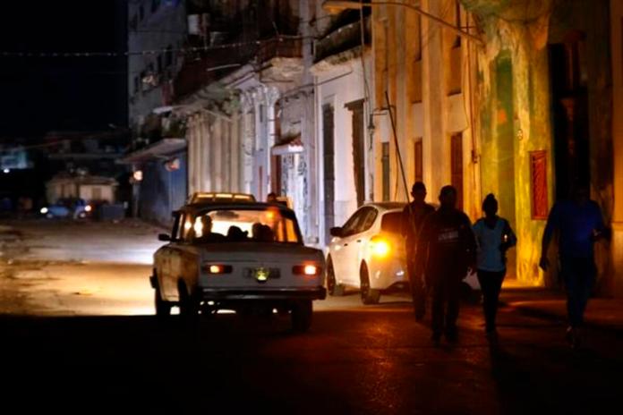 Fotografía de archivo de personas caminando por un sector sin servicio eléctrico a causa de los apagones en La Habana (Cuba). Foto La Hora: EFE