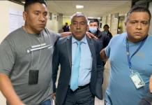 El jefe de la FECI, Rafael Curruchiche, se resguardó tras sus guardias personales para evitar las preguntas de los periodistas Sony Figueroa y Marvin del Cid. Foto La Hora: Cortesía Vox Populi