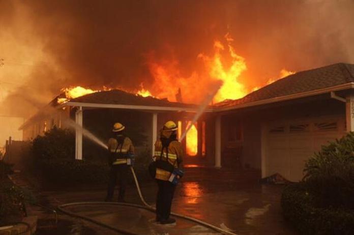 Bomberos combatiendo un incendio que envuelve una vivienda durante el incendio de Palisades, en el vecindario de Pacific Palisades, Los Ángeles, California, EE.UU. Foto La Hora : AP