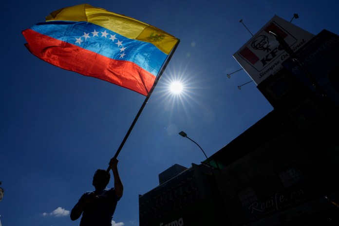 Un hombre ondea una bandera durante una protesta de opositores al presidente venezolano Nicolás Maduro el día antes de su investidura para un tercer mandato en Caracas, Venezuela, el jueves 9 de enero de 2025. Foto La Hora: AP