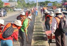 Migrantes limpian una calle este sábado, en Tapachula (México). Tapachula emplea a migrantes que quedaron varados por las restricciones del presidente de Estados Unidos, Donald Trump, para integrarlos a sus cuadrillas municipales y “embellecer” la urbe, la que recibe a más extranjeros en todo el país. Foto La Hora: EFE