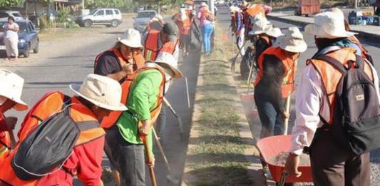 Migrantes limpian una calle este sábado, en Tapachula (México). Tapachula emplea a migrantes que quedaron varados por las restricciones del presidente de Estados Unidos, Donald Trump, para integrarlos a sus cuadrillas municipales y “embellecer” la urbe, la que recibe a más extranjeros en todo el país. Foto La Hora: EFE