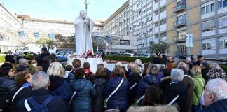 Fieles rezan por el papa Francisco ante la estatua del Papa San Juan Pablo II frente al Hospital Universitario Gemelli, donde está hospitalizado, en Roma, el 26 de febrero de 2025. Foto La Hora: EFE