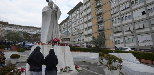 Dos monjas rezan frente a una estatua de san Juan Pablo II frente al hospital policlínico Agostino Gemelli, en Roma. Foto La Hora: AP