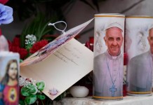 Velas con la imagen del papa Francisco se ven a los pies de la estatua al fallecido papa Juan Pablo II ante la Policlínica Agostino Gemelli en Roma,. Foto La Hora: AP