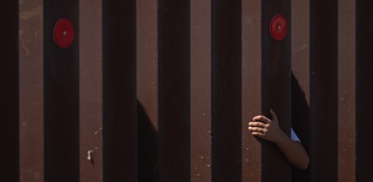 Foto de archivo que muestra a un niño se ha aferrado a la valla fronteriza de EE.UU. mientras espera a la Patrulla Fronteriza. Foto La Hora: EFE