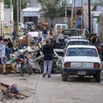 Fotografía que muestra personas caminando entre escombros ocasionados por una inundación en Bahía Blanca (Argentina). Foto La Hora: EFE