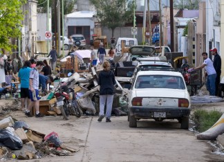 Fotografía que muestra personas caminando entre escombros ocasionados por una inundación en Bahía Blanca (Argentina). Foto La Hora: EFE