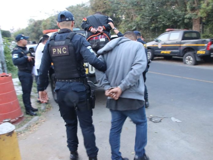 Agentes de la comisaría 14 capturando a dos presuntos asaltantes en la zona 7. Foto La Hora: PNC