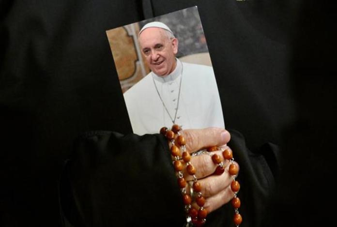 Una monja sostiene una imagen del Papa Francisco y un rosario mientras los fieles asisten a una oración del Rosario por la salud del pontífice en la Plaza de San Pedro este lunes, en la Ciudad del Vaticano. Foto La Hora: EFE