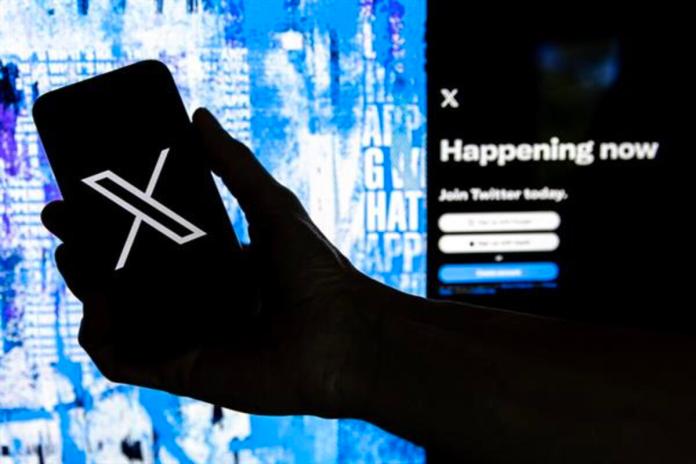 Fotografía de archivo que muestra a un usuario mientras sostiene un teléfono móvil que muestra el logotipo de la página 'X', llamada antes Twitter. Foto La Hora: EFE
