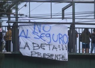 Manifestantes en el bloqueo frente a la colonia La Bethania, zona 7 colocan mantas rechazando el seguro contra terceros obligatorio presentado por la cartera del Interior.  Fotos La Hora: Fabricio Alonzo.