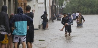 Varias personas caminan en medio de una inundación debido a fuertes lluvias este viernes, en Bahía Blanca (Argentina). Foto La Hora: EFE