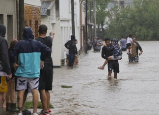 Varias personas caminan en medio de una inundación debido a fuertes lluvias este viernes, en Bahía Blanca (Argentina). Foto La Hora: EFE