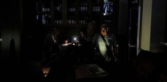 Personas en un restaurante durante el apagón masivo en España. Foto La Hora: AP