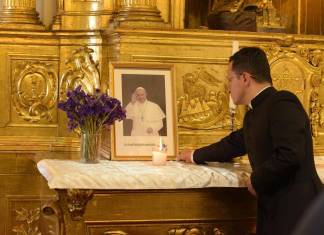 El sacerdote Luis René Sandoval Quinteros se encuentra frente a una fotografía del papa Francisco.