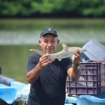 Pescador en el Atlántico de Guatemala sosteniendo un tiburón. Foto La Hora: MAGA