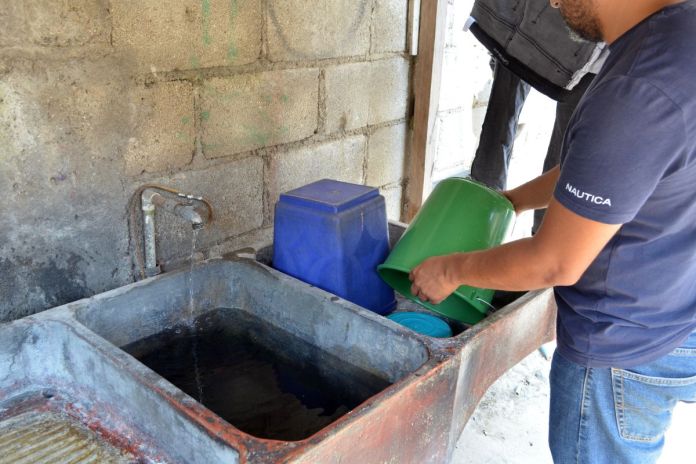 Hombre realizando el vaciado de botes y cubetas como medida de prevención para el dengue. Foto La Hora: MSPAS