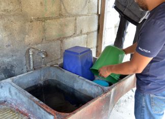 Hombre realizando el vaciado de botes y cubetas como medida de prevención para el dengue. Foto La Hora: MSPAS