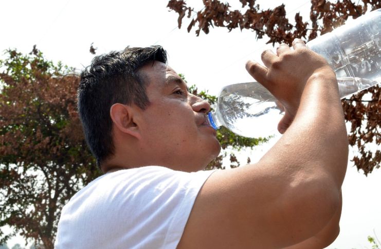 Hombre manteniéndose hidratado para prevenir un golpe de calor. Foto La Hora: MSPAS