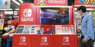 Un hombre camina junto a un expositor de Nintendo Switch en una cadena de tiendas de electrónica en Tokio, el 13 de octubre de 2021. Foto La Hora: AP Archivo.