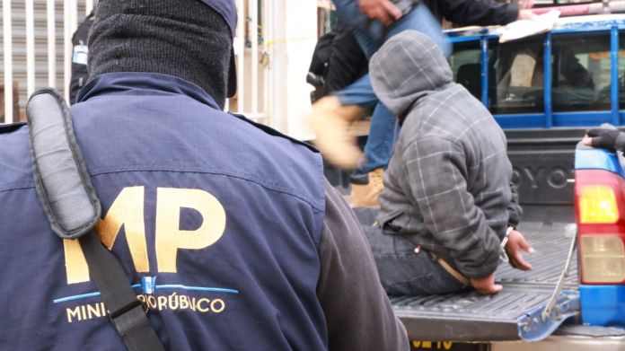 Una persona detenida por las autoridades tras un allanamiento por delitos relacionados con el crimen organizado y extorsión. Foto: La Hora / MP.