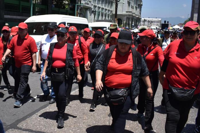 Sandra Carolina Méndez Duarte, dirigente de la filial del STEG en Zacapa, frente a Joviel Acevedo con una botella en la mano y chaleco negro abierto. Foto La Hora: Daniel Ramírez