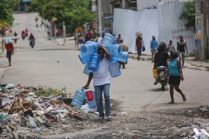 Archivo de hombre cargando garrafones de agua en Prince, Haiti. Foto La Hora: AP