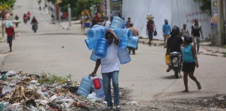 Archivo de hombre cargando garrafones de agua en Prince, Haiti. Foto La Hora: AP