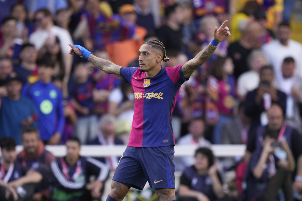 Raphinha cruza de rodillas el césped del estadio de Montjuïc luego de la gran temporada del Barcelona